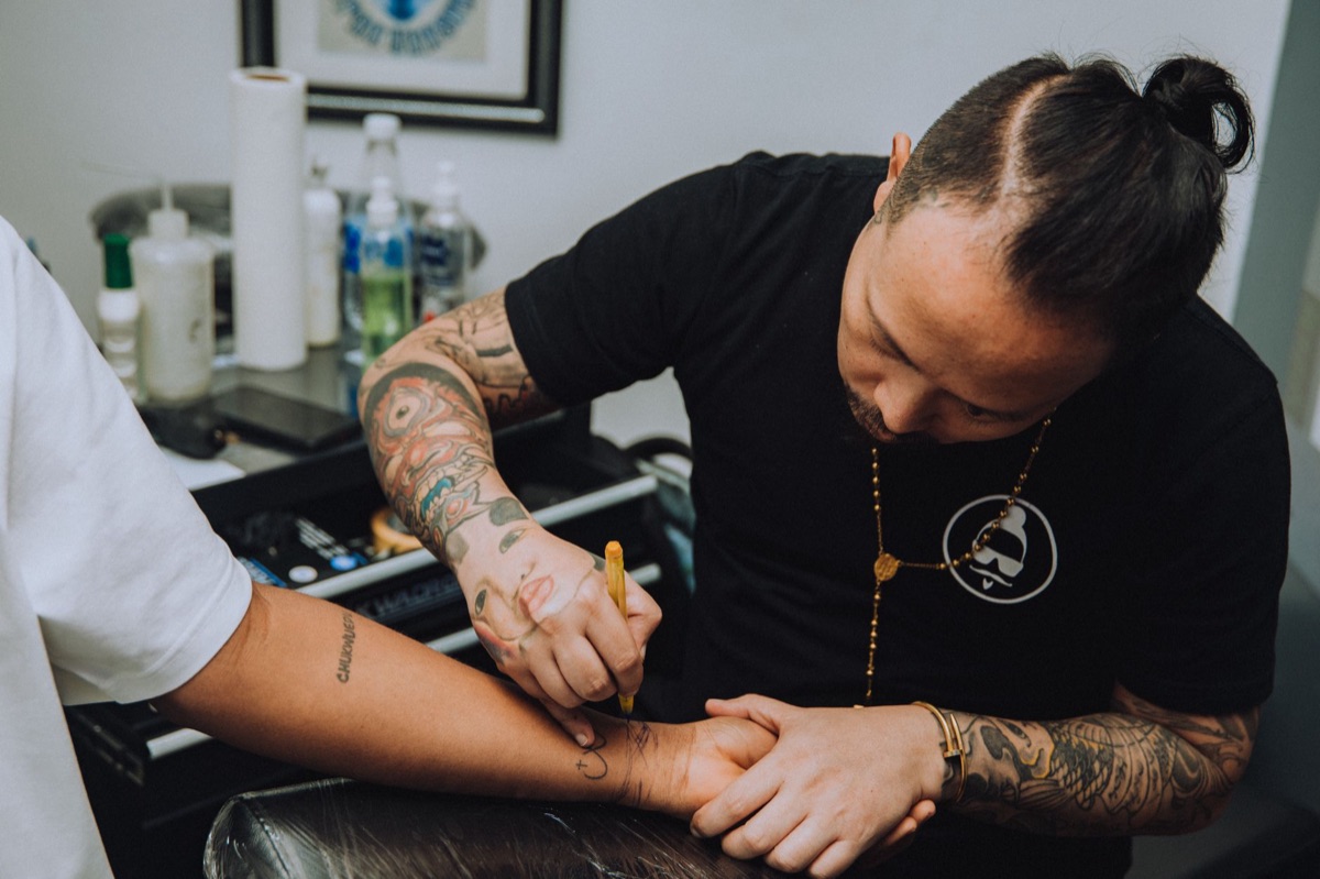 Um artista chamorra tradicional fazendo tatuagem em um vilarejo local.