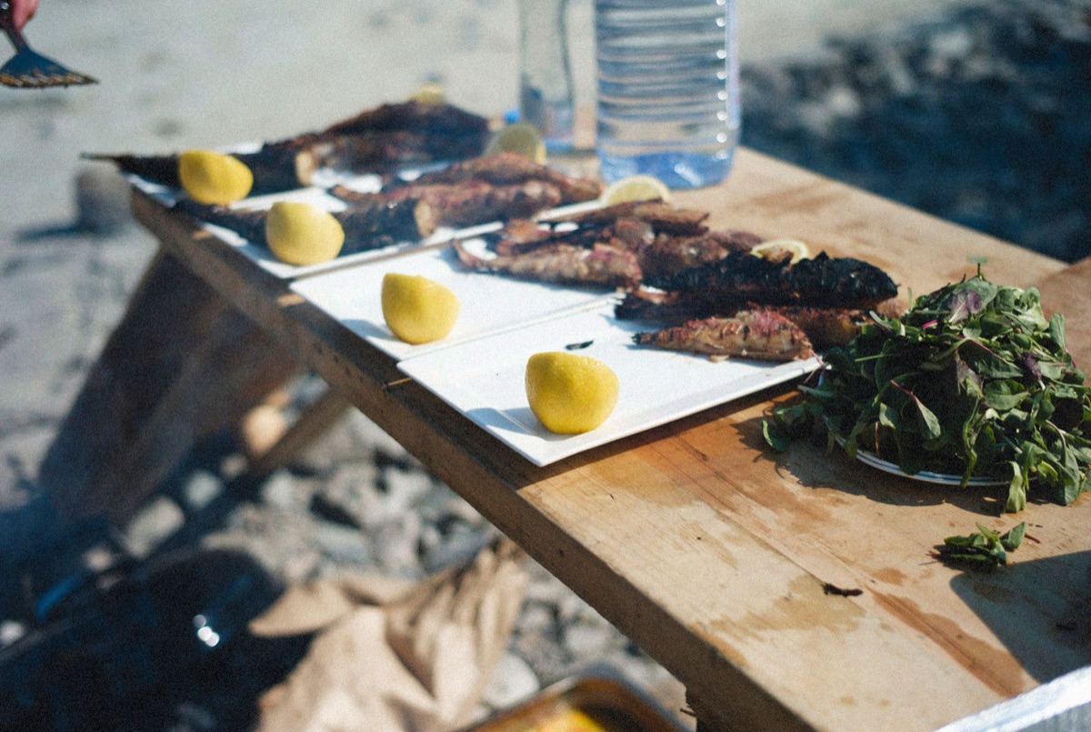 Dinner table with tropical fruit and grilled fish
