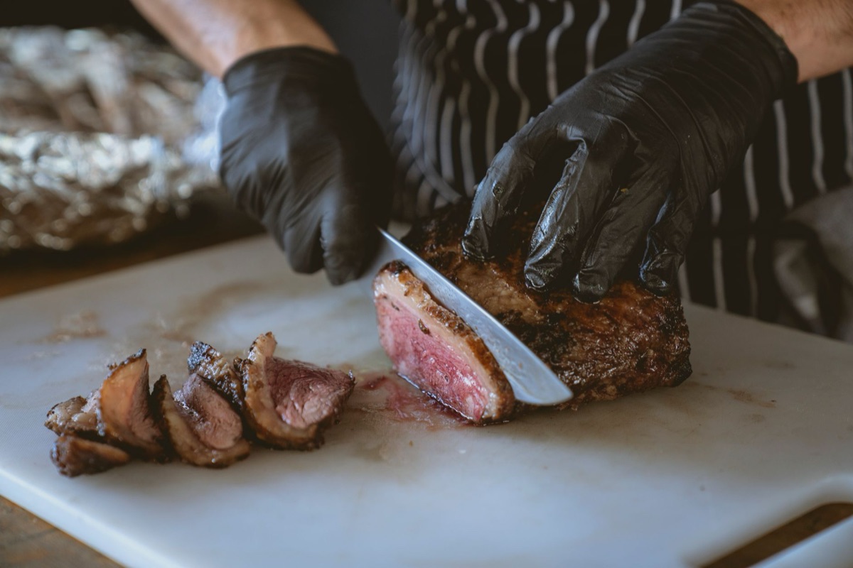Locale chef bereidt steak aan in een zonnestralige keukentijd
