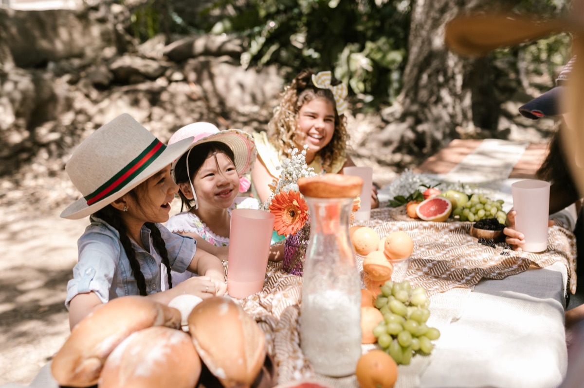 tavolo con bambini e cibo locale
