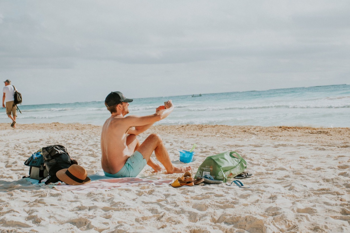 Kinder op strand met zonscreen en zonnescherm