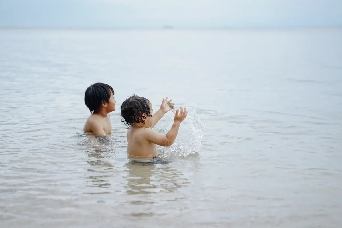 兩個孩子在印尼巴 Nyuwangi 私人海灘享受玩樂的時刻。